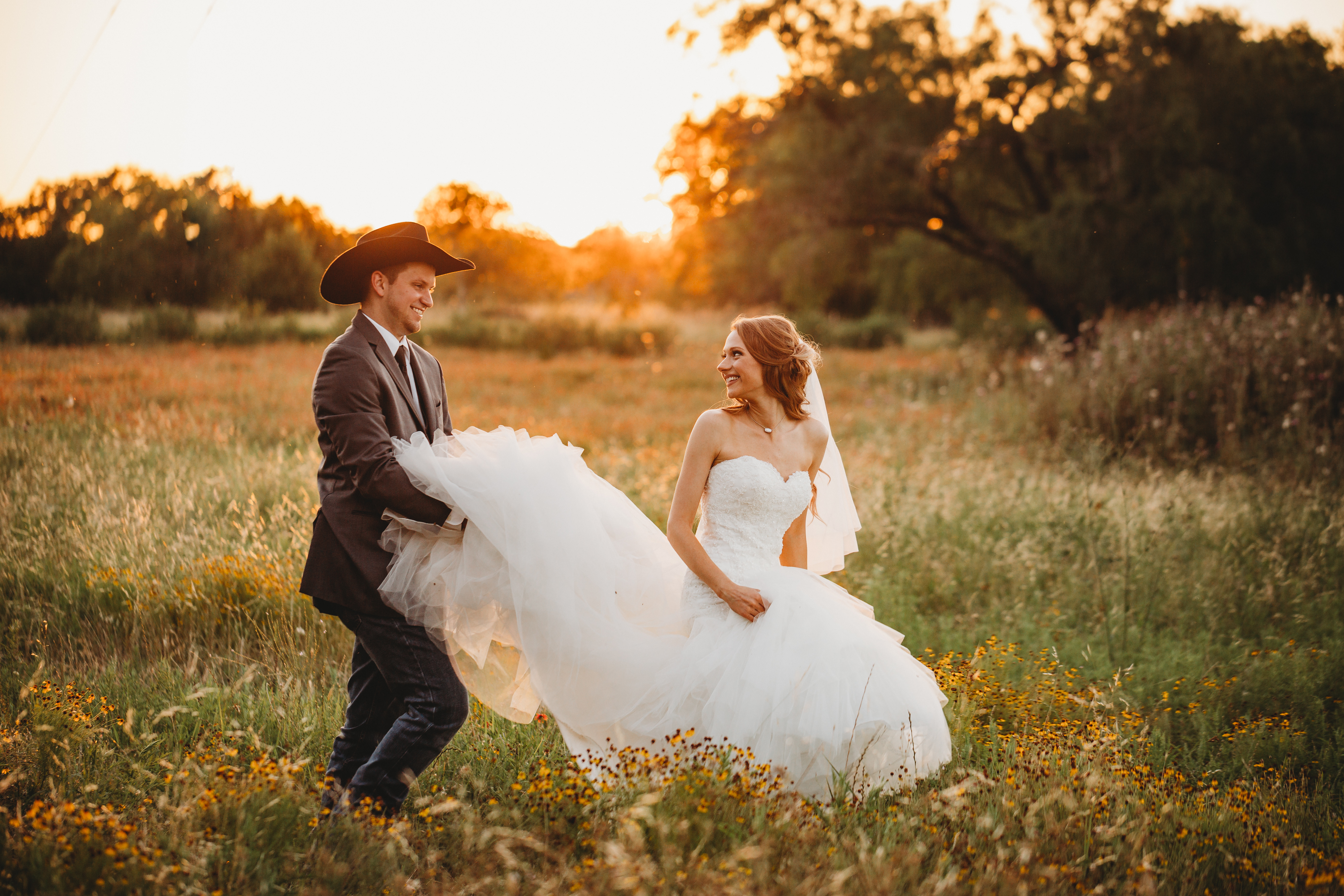 bride and groom walk in field at King River Ranch in Johnson City, Texas
