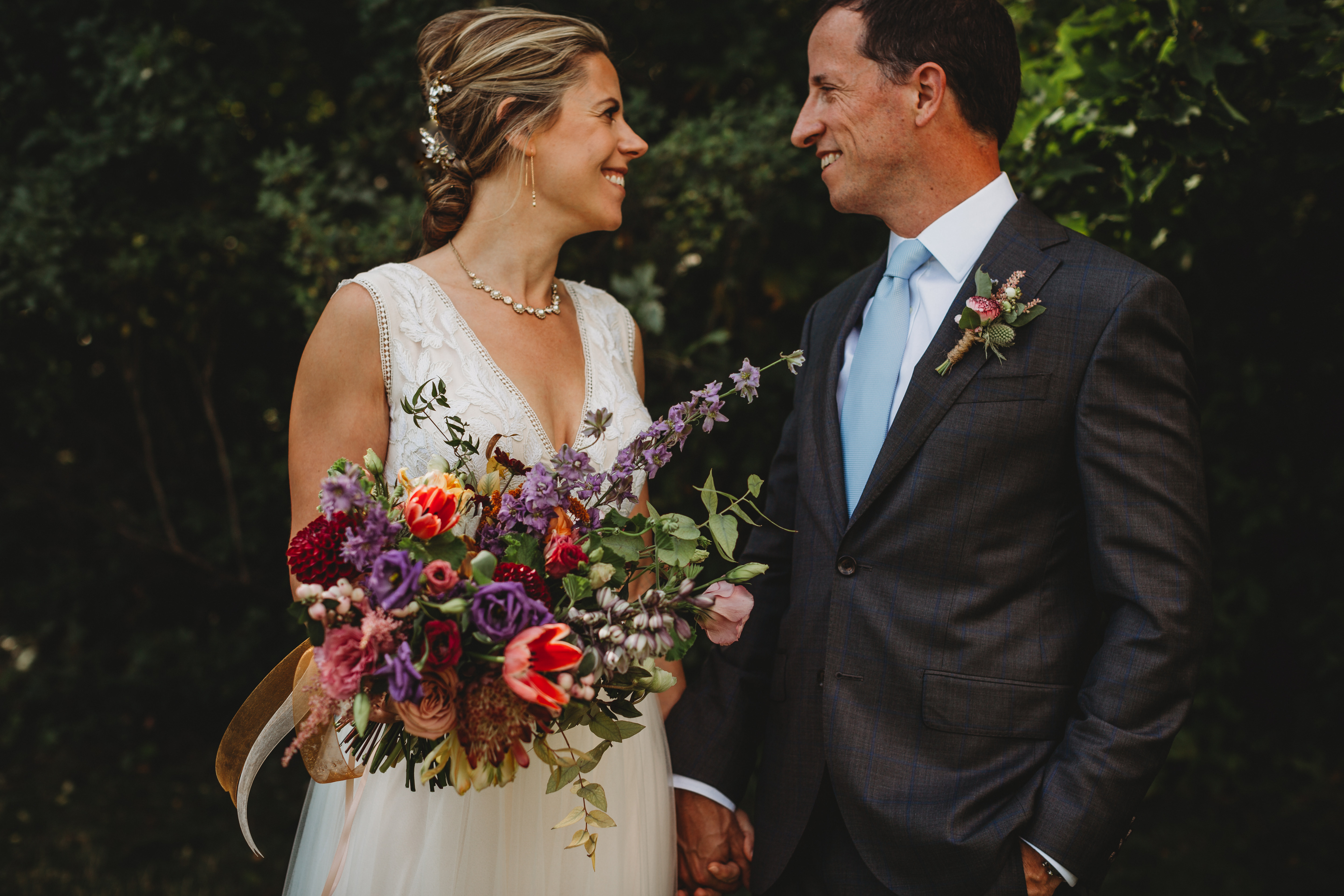 bride and groom hold flowers at Chautauqua Park in boulder colorado