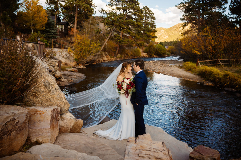 Bride and groom celebrate their wedding by the river at The Landing in Estes Park.